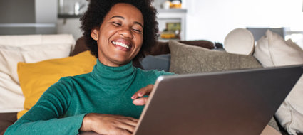 person sat on a sofa using a laptop